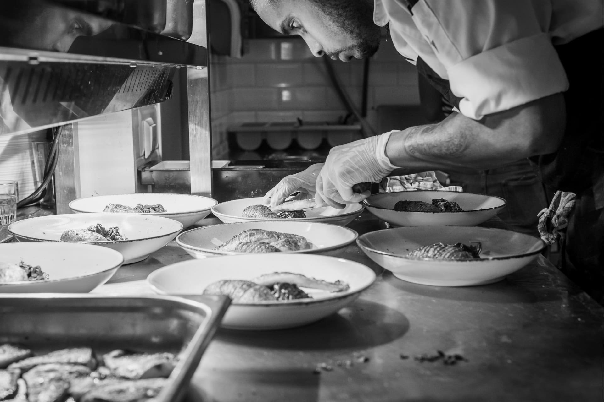 a chef checking on plated meals